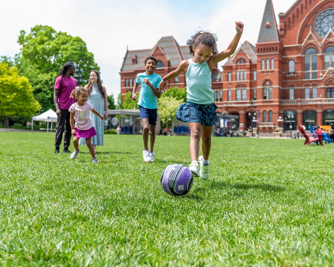 Girl kicking a ball at Washington Park
